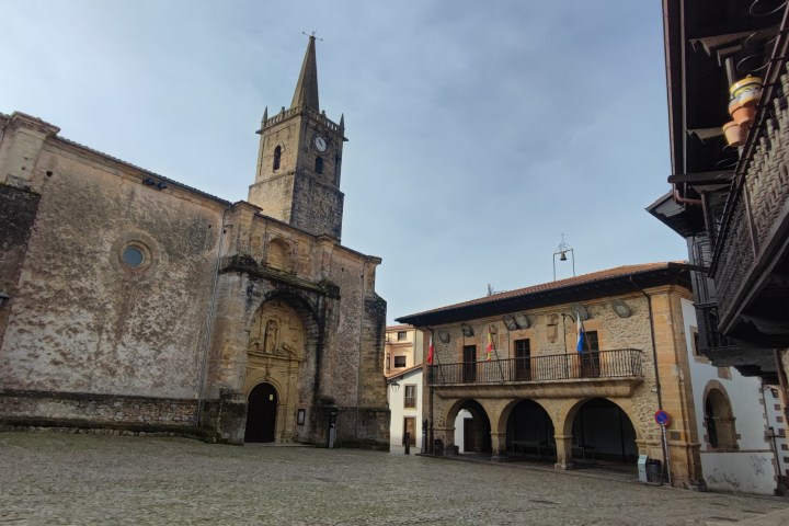 Historic church and building in a cobblestone square.