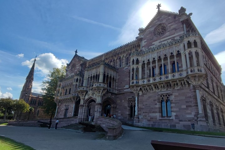 Gothic-style stone building with decorative facade under a blue sky.