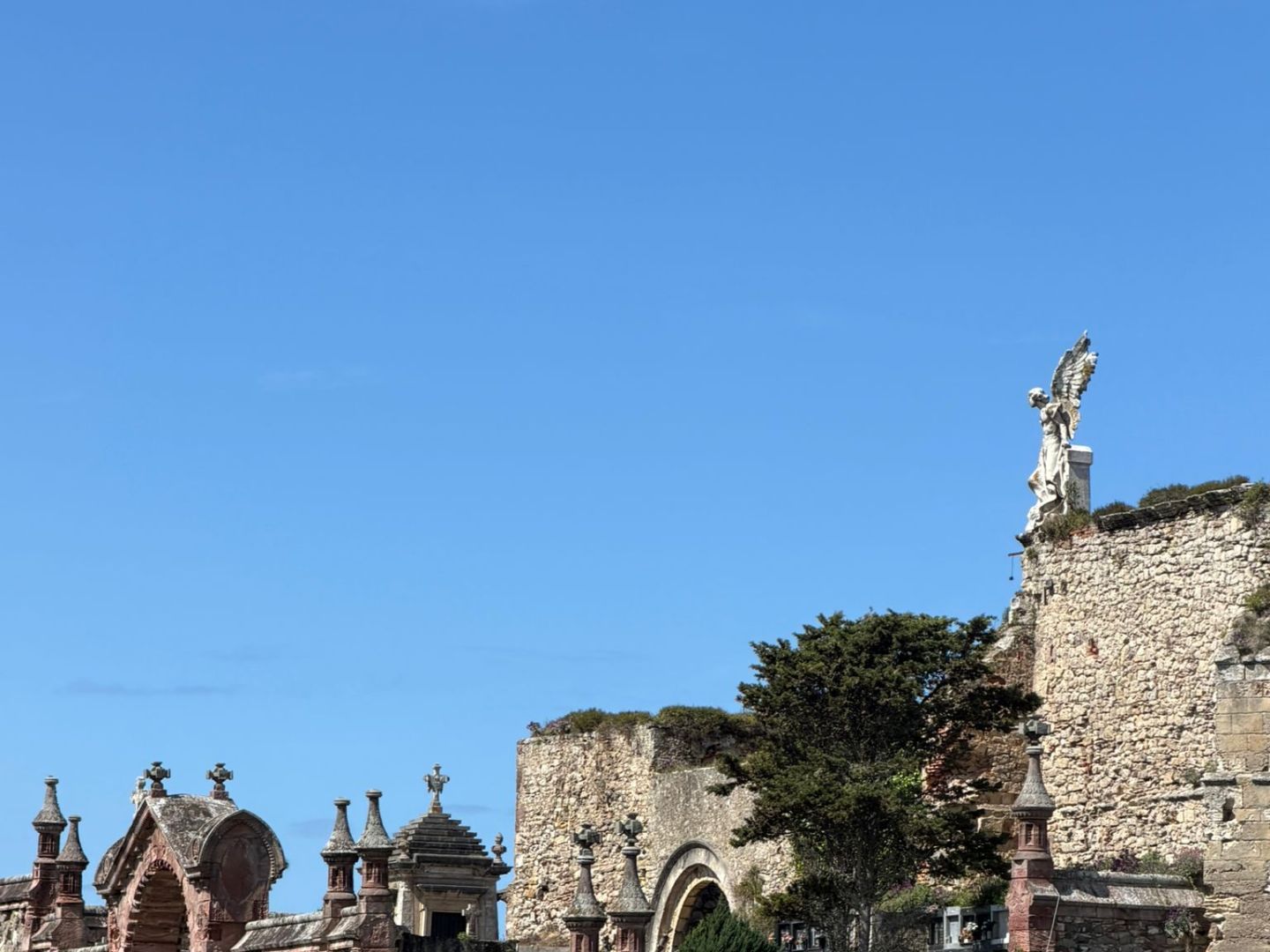 Ancient stone buildings and statues under a clear blue sky.