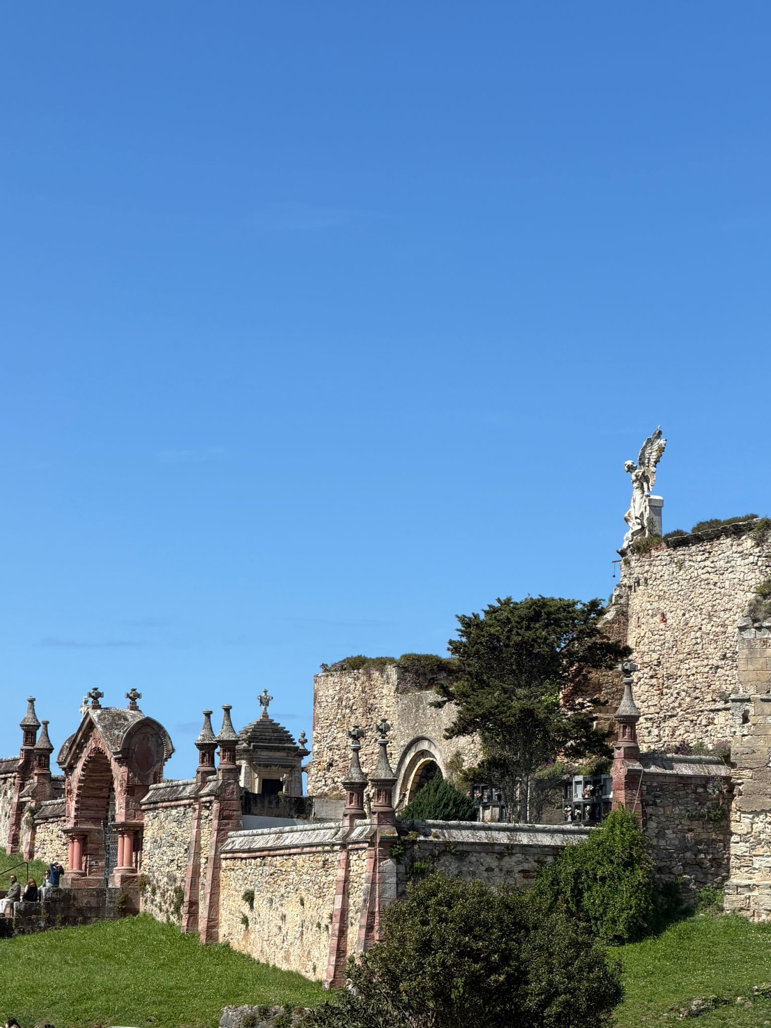 Ancient stone buildings and statues under a clear blue sky.