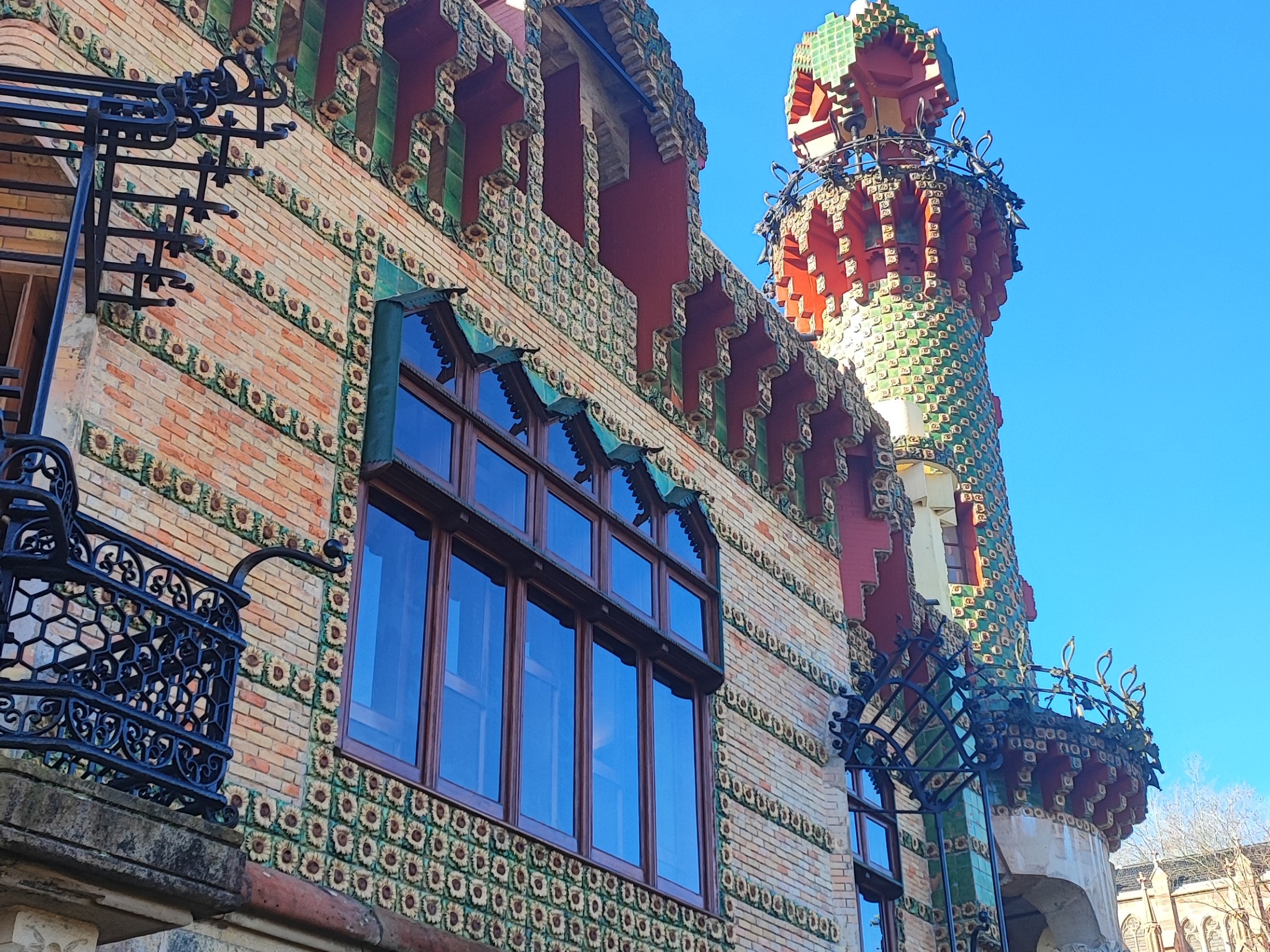Colorful, whimsical building with tower and ornate designs, blue sky background.