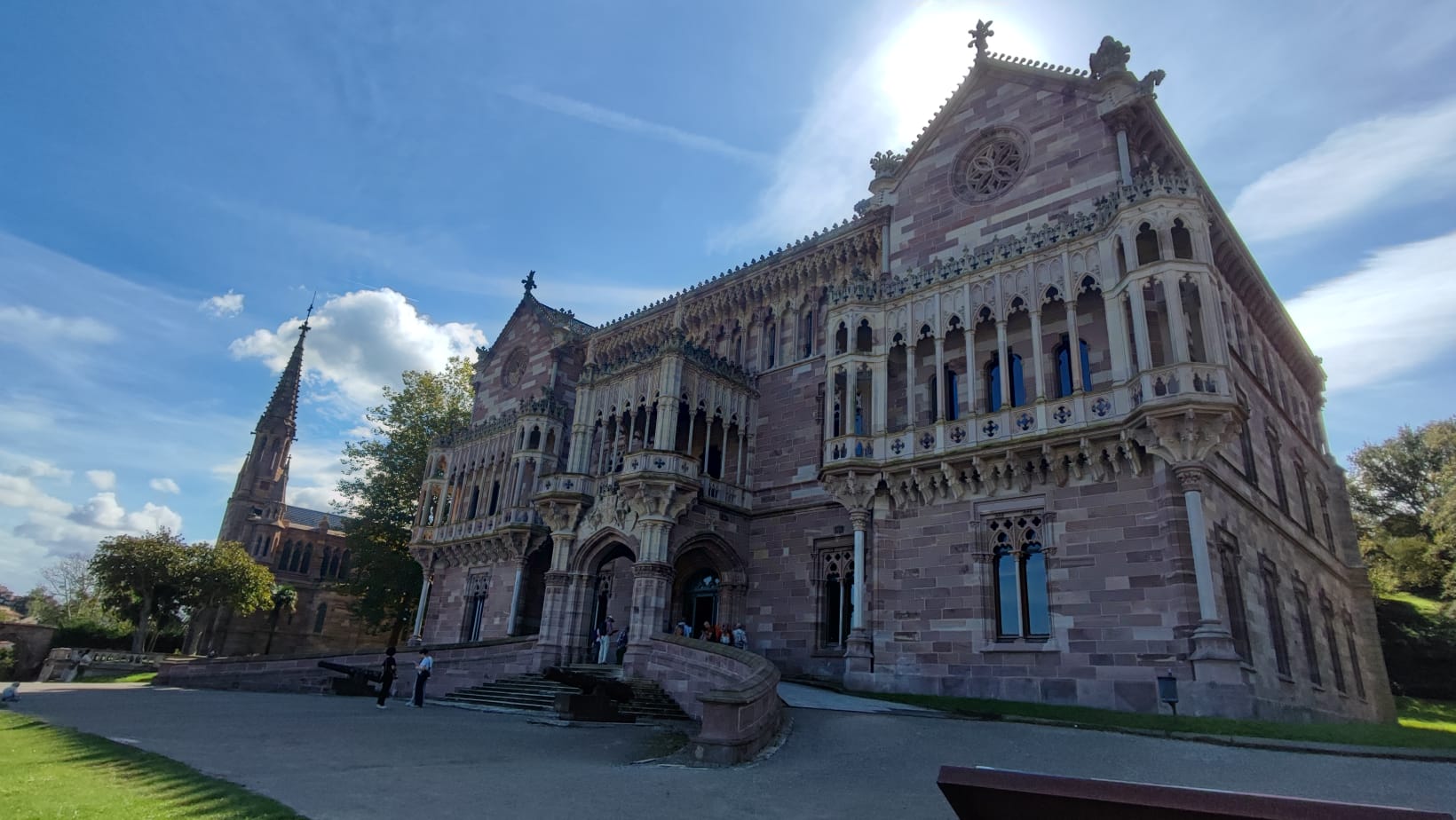 Historic castle-like building with ornate stonework under a blue sky.