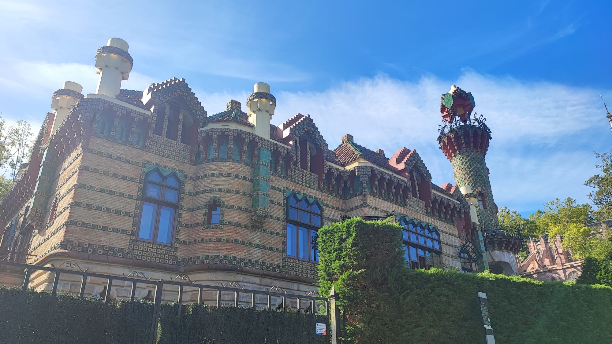 Colorful, ornate building with towers and blue sky.